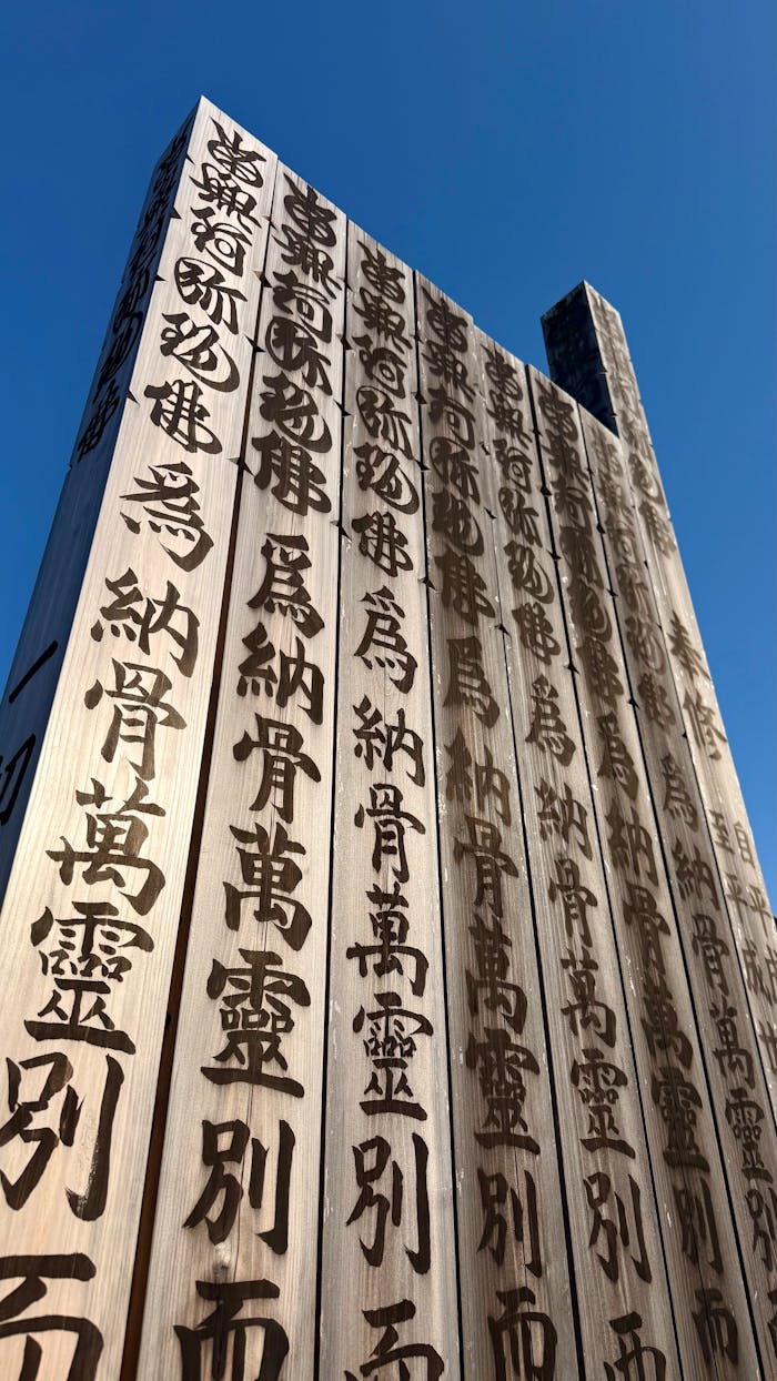 Wooden structures adorned with Japanese Kanji against a clear blue sky.